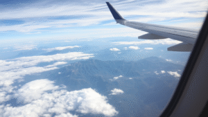 Airplane window view flying over United States landscape mountains clouds no text no words no letters