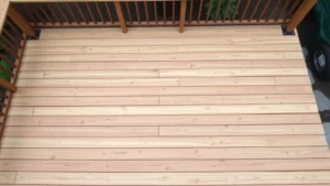 Overhead view of completed wooden deck with pressure-treated joists and rim boards visible, showing proper spacing and construction details, surrounded by landscaping
