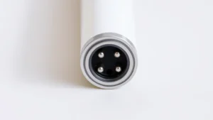 Close-up of Apple Pencil Gen 1 Lightning connector port at the base, showing metallic charging pins and surrounding cylindrical body, photographed against neutral background with natural lighting