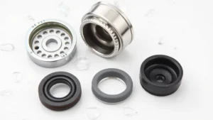 Close-up of a disassembled faucet aerator showing individual components including screens, housing, rubber washer, and flow restrictor laid out on white surface with water droplets